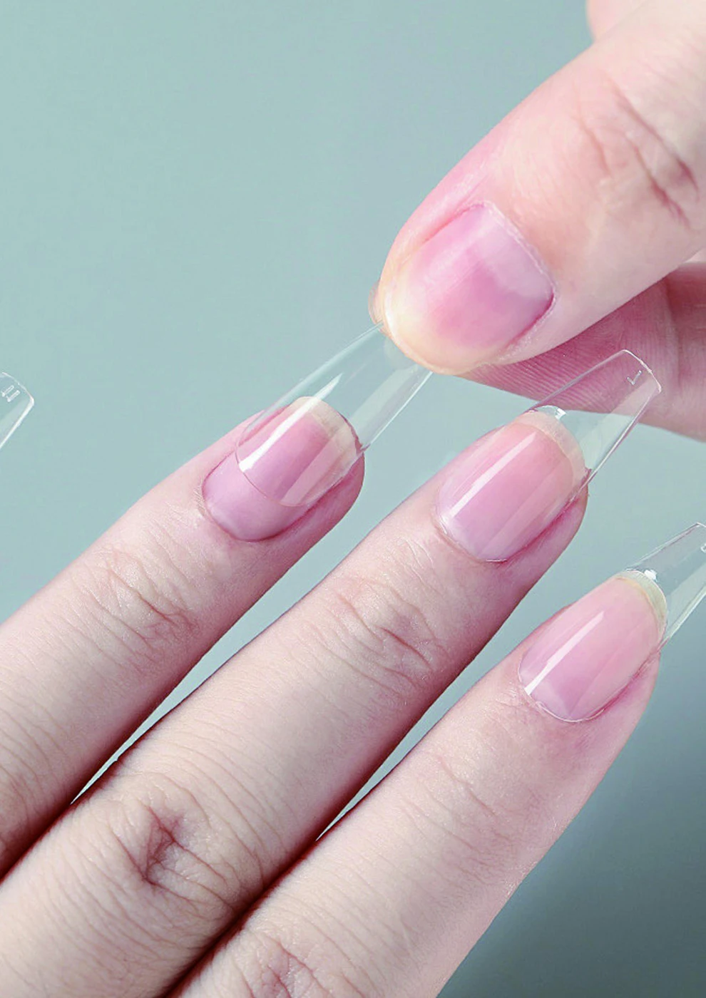 Clear nail tips shown on a hand in the TENTEU catalog